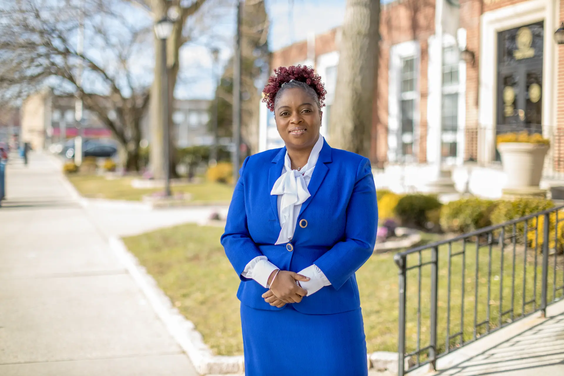 Dr. Clariona Griffith in a royal-blue suit, standing outside Hempstead Village Hall
